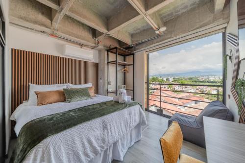 a bedroom with a bed and a large window at Epic Suites x Ahead in Pereira