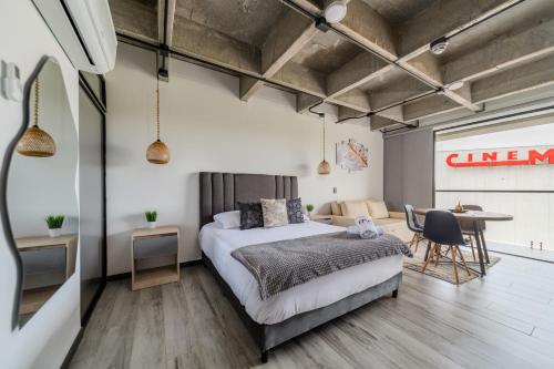a bedroom with a bed and a dining room at Epic Suites x Ahead in Pereira