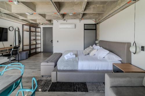 a bedroom with a large bed and a couch at Epic Suites x Ahead in Pereira