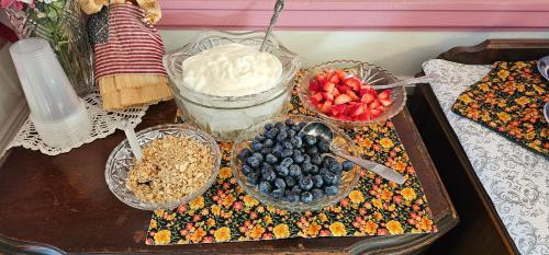 a table topped with bowls of fruit and yogurt at Belle Aire Mansion Guest House in Galena