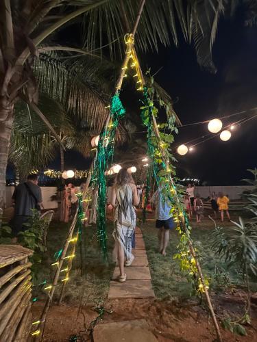 a group of people walking down a walkway with lights at SOLS Backyard in Arambol