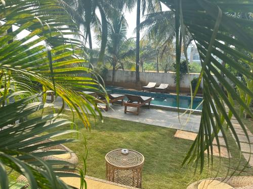 a backyard with a pool with two chairs and a table at SOLS Backyard in Arambol