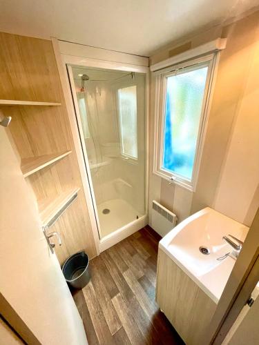 une salle de bain avec un lavabo blanc et une douche dans l'établissement Le Refuge, Mobil Home 3 rooms avec Climatisation, à Samoëns