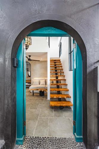 an archway leads into a room with a staircase at Domo Nosara in Nosara