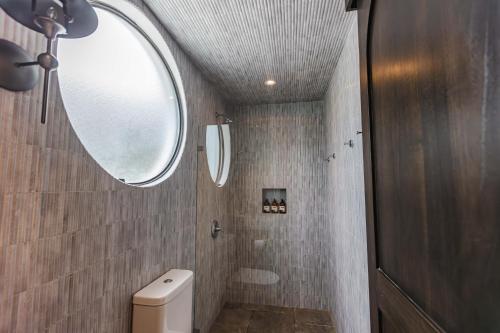 a bathroom with a toilet and a mirror at Domo Nosara in Nosara