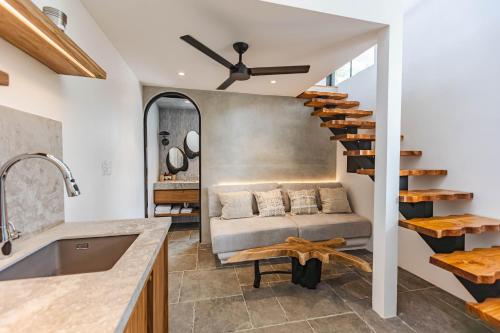 a living room with a couch and a spiral staircase at Domo Nosara in Nosara