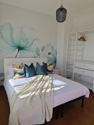 a bedroom with a large bed with a flower mural on the wall at Villa Greta Hotel Rooms & Suites in Taormina
