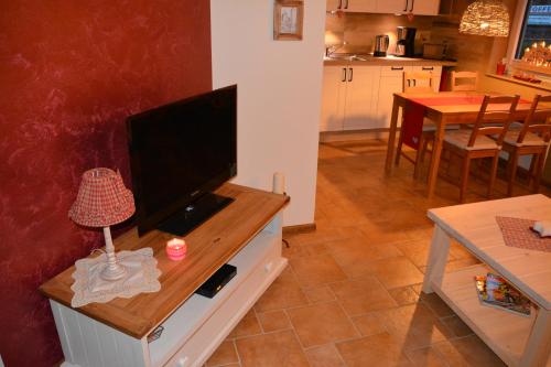 a living room with a flat screen tv on a dresser at Ferienappartements "Landromantik" in Bautzen