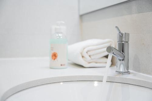a bathroom sink with water coming out of a faucet at Family Flat Near Porto in Rio Tinto