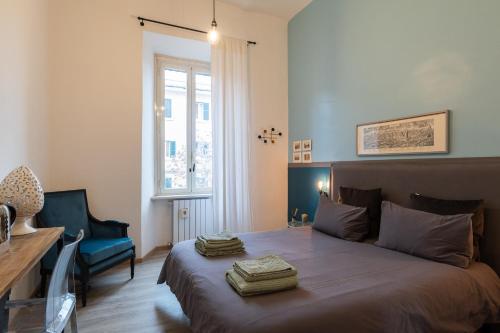 a bedroom with a bed and a chair and a window at A Casa Lamperini 59 in Rome