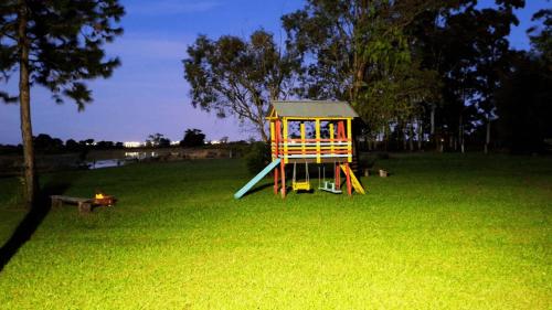 a playground in the middle of a grass field at Chalézinho Bons Ventos Campestre no Sitio com Churrasqueira WI-FI a 6km da Estrada do Mar 7km Parque de Rodeio II 8,1Km Prefeitura II 7,2Km UFRGS Litoral II Taxi Fácil II Tranquilidade 12km Praias Tramandai in Osório