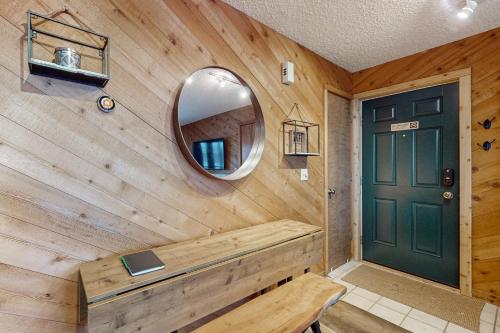 a room with a wooden wall with a mirror and a door at Snowshoe Condo in Bellaire