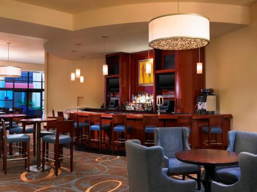 a bar in a hotel room with tables and chairs at Sheraton Agoura Hills Hotel in Agoura Hills