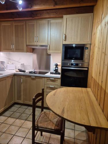 a kitchen with a wooden table and a microwave at Chalet Des Charmes in Thollon