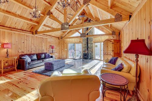 a living room with wooden walls and a wooden ceiling at 15 Mi to Snowshoe Resort Cabin with Deck and Fire Pit in Dunmore