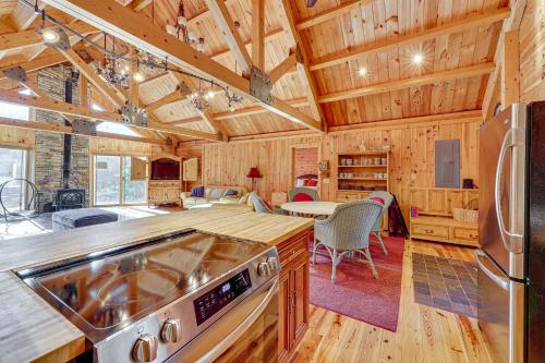 a kitchen with a stove top oven in a room at 15 Mi to Snowshoe Resort Cabin with Deck and Fire Pit in Dunmore