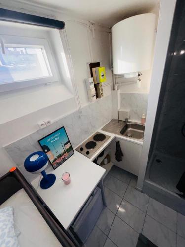 une petite cuisine avec une table et un ordinateur portable. dans l'établissement Place à quelques pas du Musée du Louvre au Centre de Paris, à Paris