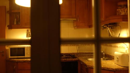 a kitchen with a sink and a microwave at Casa da Quelha in Chãs de Égua