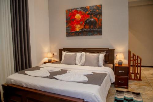 a bedroom with a large bed with two pillows at Villa White Elephant in Hikkaduwa