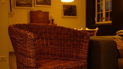 a wicker couch sitting in a living room at Casa da Quelha in Chãs de Égua