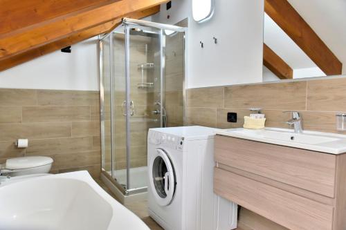 W łazience znajduje się pralka i umywalka. w obiekcie La Pieve Apartments w mieście San Lorenzo in Banale