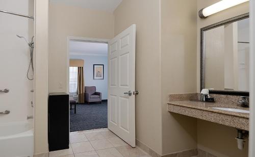 a bathroom with a sink and a mirror at Sonesta Essential Houston Westchase in Houston