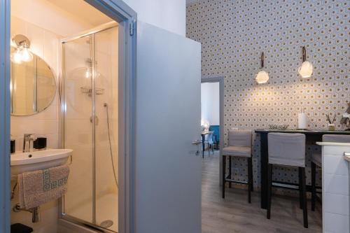 a bathroom with a shower and a sink and a table at A Casa Lamperini 59 in Rome