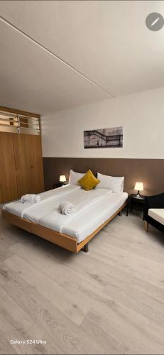 a large white bed in a room with two lamps at Residenza Lago di Lugano in Bissone