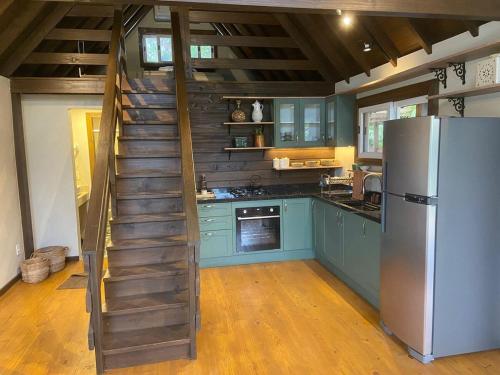 a kitchen with a staircase leading up to a refrigerator at Cabana Encantada in Garopaba