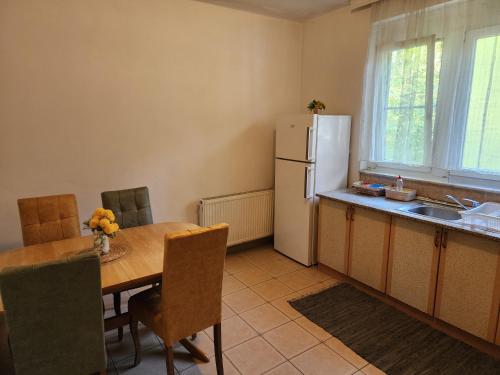 a kitchen with a table and a white refrigerator at City Park Apartments in Pristina