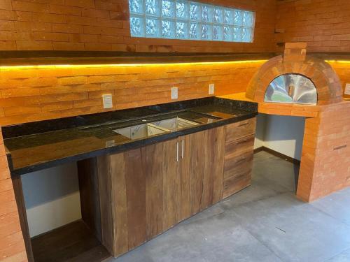 a kitchen with a counter top and a window at Cabana Encantada in Garopaba