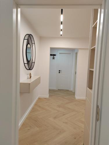 a hallway with a mirror and a sink at Central Residence Câmpulung in Cîmpulung
