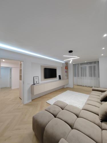 a living room with a couch and a flat screen tv at Central Residence Câmpulung in Cîmpulung