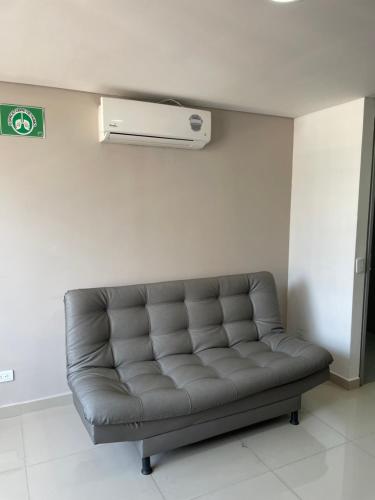 a leather couch in a room with a air conditioner at Ivanna Jumar ApartaHotel in Medellín