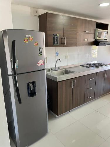 a kitchen with a refrigerator and a sink at Ivanna Jumar ApartaHotel in Medellín