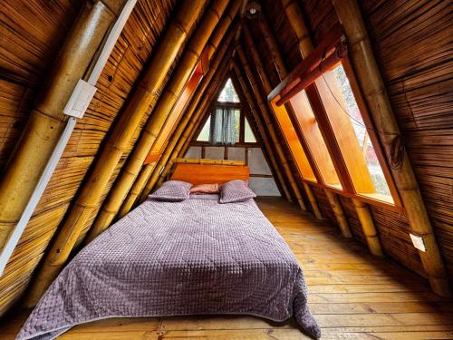 a bed in a room in a log cabin at Glamping Los Nidos in San Augustín