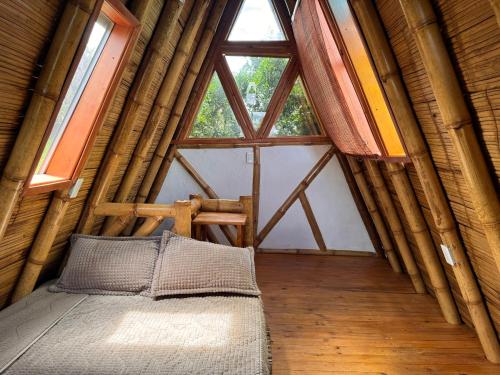 a bed in a room with a large window at Glamping Los Nidos in San Augustín
