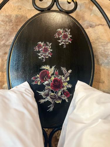 a black chair with flowers on it with glasses at Pietra Rossa in Chios