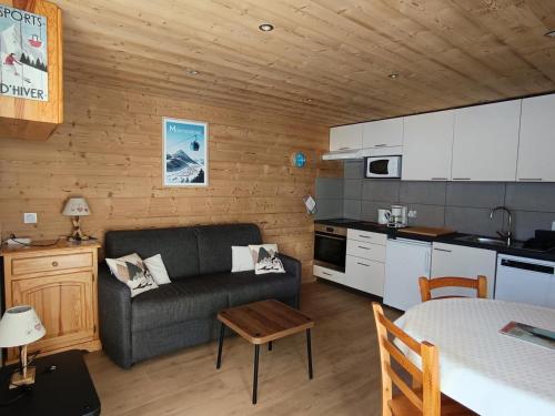 un salon avec un canapé et une cuisine dans l'établissement Résidence Alpet I - Superbe studio entièrement rénové - Sud - Balcon - Parking MAE-7561, à Montgenèvre