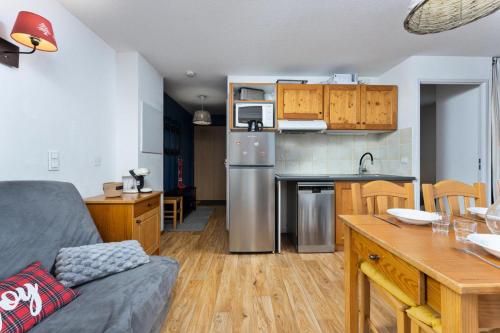 une cuisine et un salon avec un réfrigérateur en acier inoxydable dans l'établissement Les Chalets De Bois MÉan - B - Chaleureux appartement avec vue dégagée MAE-5251, aux Orres