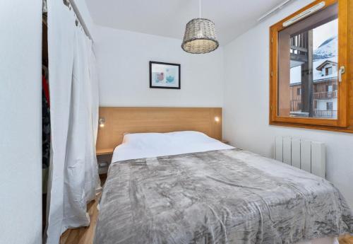 une chambre avec un lit et une fenêtre dans l'établissement Les Chalets De Bois MÉan - B - Chaleureux appartement avec vue dégagée MAE-5251, aux Orres
