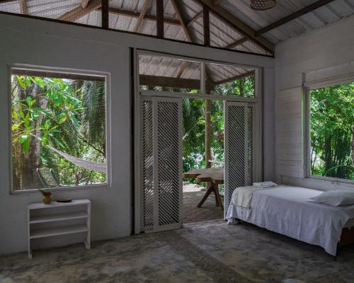 a bedroom with a bed and two large windows at Hotel Fuerte Mayal in Isla Fuerte