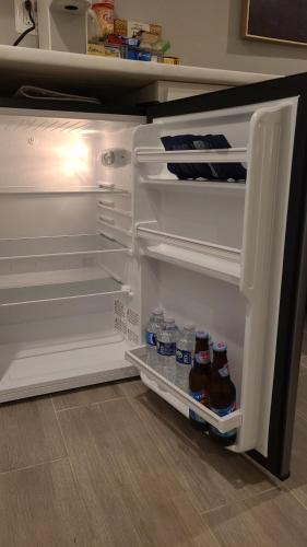 an open refrigerator with bottles of beer in it at Beautiful Basement Suite & Outdoor Oasis in Washington, D.C.