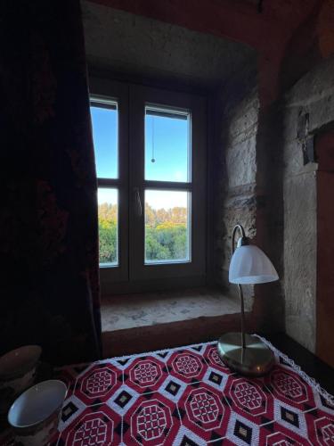 a room with a table with a lamp and a window at Pietra Rossa in Chios