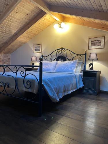 a bedroom with a bed with a blue comforter and two lamps at Pietra Rossa in Chios