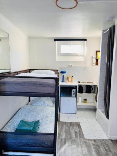 two bunk beds in a small room with a kitchen at Place à quelques pas du Musée du Louvre au Centre de Paris in Paris