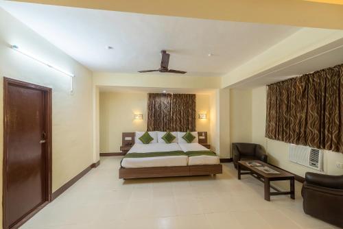 a bedroom with a bed and a couch in a room at Treebo Green Park in Mapusa