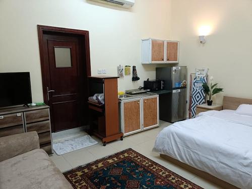 a living room with a bed and a kitchen at Khalifa A studio Room 13-6 in Abu Dhabi