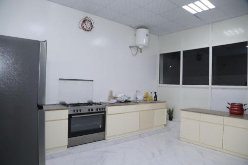 eine Küche mit weißen Schränken und einem Herd mit Backofen in der Unterkunft Malina Resort منتجع مالينا in Ras al Khaimah