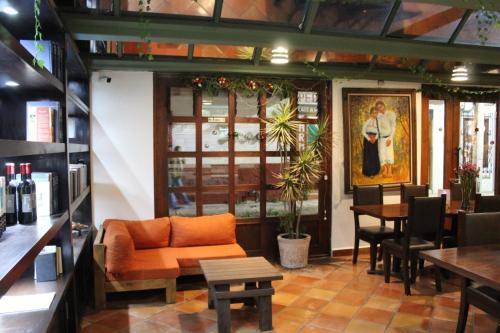 a restaurant with an orange couch and a table at Axkan Arte Hotel in San Cristóbal de Las Casas